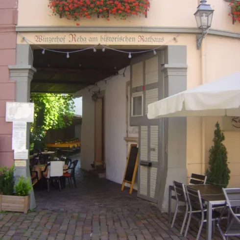 Ein Tor als Eingang zu dem Innenhof des Restaurants. Blühende Pflanzen schmücken die Wände.