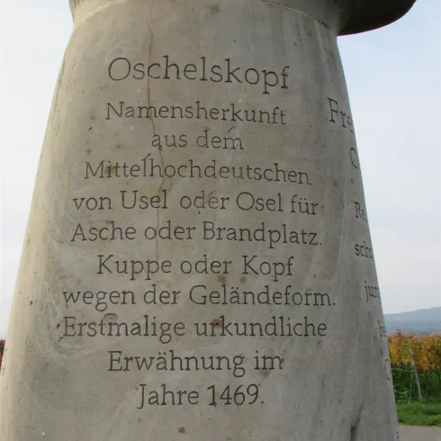 Ein Bild der skulptur namens Oschelskopf. Man sieht auch die Innenschrifft auf der Skulptur.