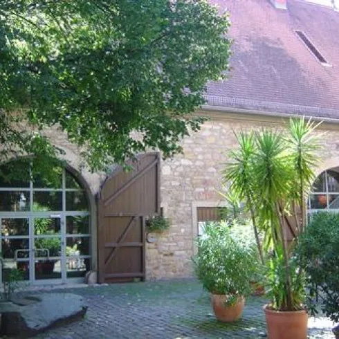 Bürgersaal Von -Busch-Hof mit Eingangstür und begrüntem Innenhof