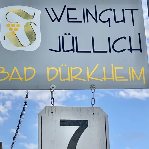 Ein Schild des Weinguts Jülich in Bad Dürkheim. Darunter hängt eine Nummer 7.