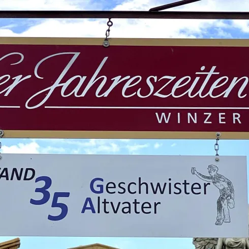 Ein Geschäftsschild mit der Aufschrift "Vier Jahreszeiten WINZER EG" und der Standnummer 35. Darunter steht "Geschwister Altvater".