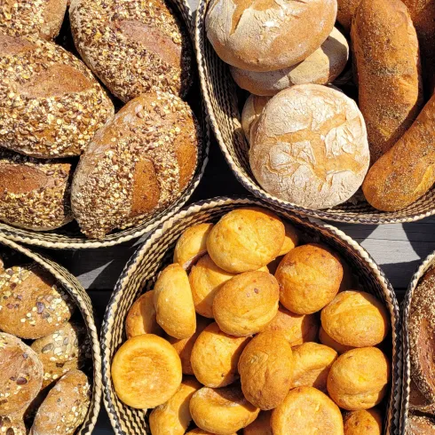 Frische Brötchen und Brote in geflochtenen Körben. Eine Vielzahl von verschiedenen Sorten und Formen, die appetitlich präsentiert sind.
