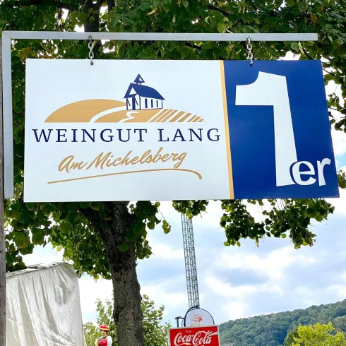 Ein Schild des Weinguts Lang am Michelberg. Der Schriftzug zeigt den Namen des Weinguts und eine Nummer.