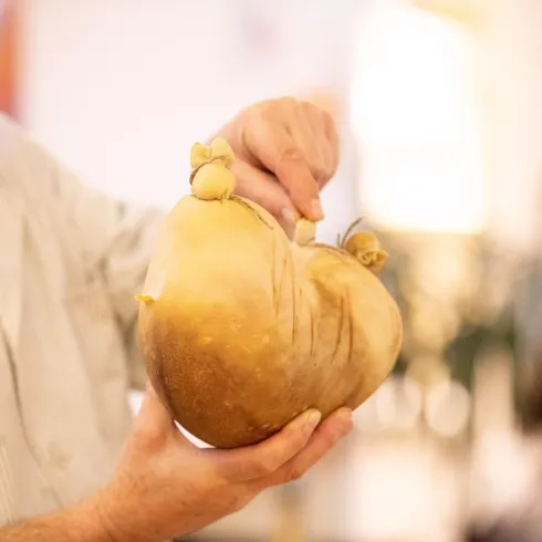 Eine Person hält einen ganzen Saumagen in der Hand