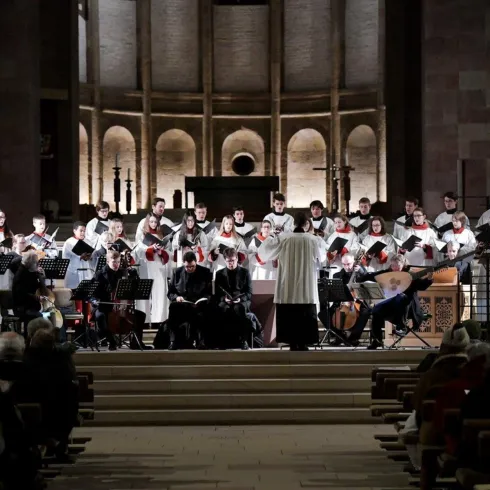 Eine beeindruckende Orgel mit vielen metallischen Pfeifen ist im Vordergrund zu sehen. Im Hintergrund erstreckt sich der große Raum einer Kirche.