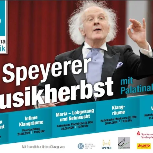 Ein Mann steht auf der Bühne und dirigiert mit leidenschaftlicher Gestik. Im Hintergrund sind Informationen zu einem Musikfestival in Speyer abgebildet.