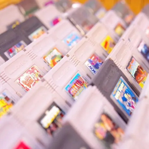 Eine Ansammlung von Spielkassetten in verschiedenen Farben und Designs. Die Kassetten sind ordentlich in einem Regal angeordnet.