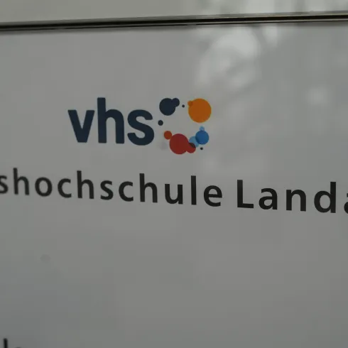 Das Bild zeigt das Logo und den Namen der Volkshochschule Landau. Es ist ein klarer und informativer Schriftzug auf einem weißen Hintergrund.