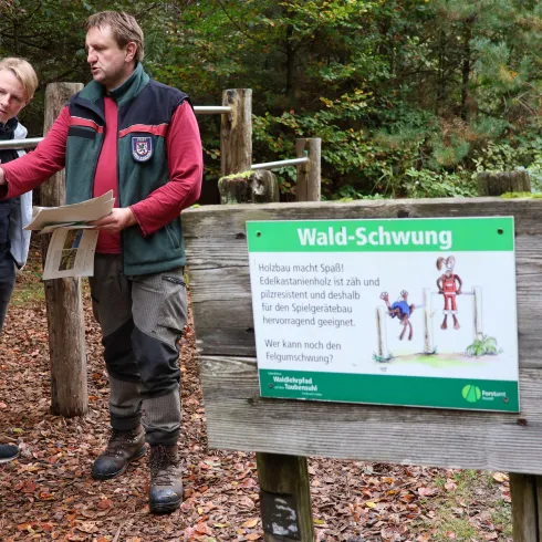 <p>Pressemitteilung der Stadt Landau: Frisch sanierter Landauer Waldlehrpfad zeigt die Geheimnisse des Taubensuhls, 
Forstwirt Stefan Günther zeigt BM Lukas Hartmann</p>