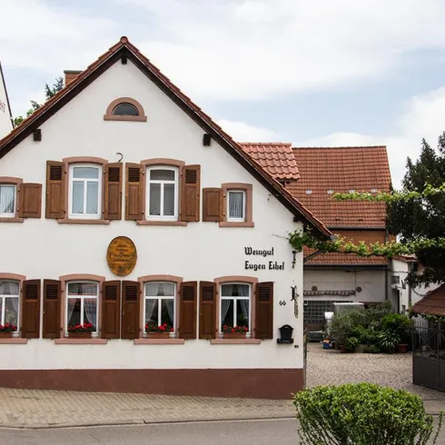 Ein charmantes, traditionelles Haus mit Holzfensterläden. Es liegt in einer ruhigen Straße und hat einen einladenden Garten.