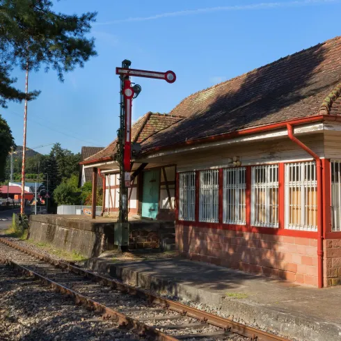 Bahnhof Hinterweidenthal Ort; altes Fachwerkgebäude restauriert, davor ein Pfosten mit Signalscheibe