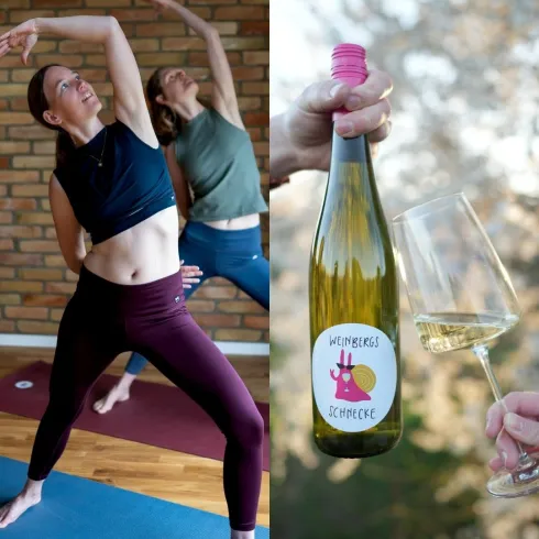 Zwei Frauen machen Yoga in einem hellen Raum mit Holzfußboden. Links ist eine Flasche Wein und ein Weinglas zu sehen, die auf eine entspannte Atmosphäre hinweisen.