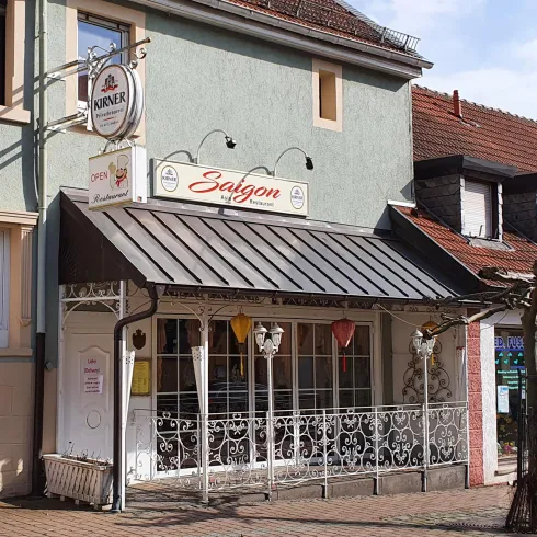 Ein Restaurant mit dem Namen "Saigon" und einer einladenden Fassade. Die Außenbereiche sind mit verschiedenen Farben dekoriert und strahlen eine gemütliche Atmosphäre aus.