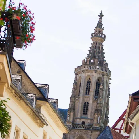 Eine malerische Straße mit Blick auf einen schönen Kirchturm. Die Architektur ist charmant und lädt zum Bummeln ein.