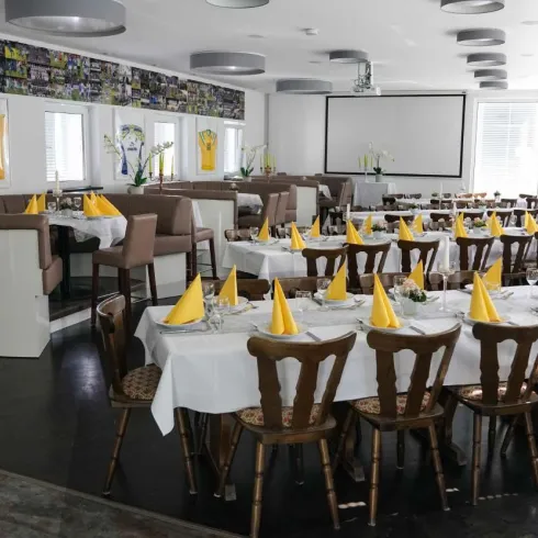 Nebenzimmer Gaststätte SC Hauenstein mit Tischen und Bestuhlung. Auf den Tischen Tischdecken, Besteck, Servietten, Kerzen