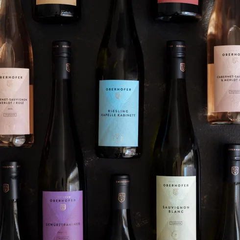 Eine Auswahl verschiedener Weinflaschen, die ordentlich angeordnet sind. Die Flaschen zeigen verschiedene Etiketten und Farben, darunter Rosé, Weiß und Rotwein.
