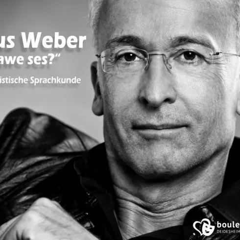 Ein Porträt eines Mannes mit kurzer, grauer Haarfrisur und einer Brille. Er trägt eine schwarze Jacke und schaut direkt in die Kamera.