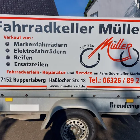 Ein Anhänger mit dem Schriftzug "Fahrradkeller Müller". Er bietet den Verkauf und die Reparatur von Fahrrädern, Elektrofahrrädern und Ersatzteilen an.