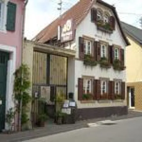 Ein charmantes altes Gebäude mit Blumenkästen an den Fenstern. Es befindet sich an der Straße in einer schönen Umgebung.