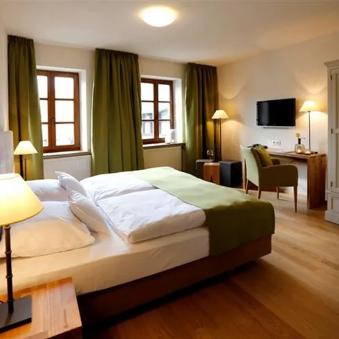 Ein Schlafzimmer mit grünen Details und einem großen Bett in der Mitte.