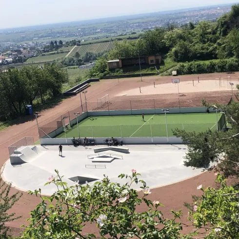 Man sieht die Freizeitanlage bei Kallstadt, Diese hat eine äußere Laufbahn. In der Mitte ist der Platz in drei aufgeteilt, und zwar ein kleiner Skatepark, ein Fußballplatz und ein Volleyballfeld.