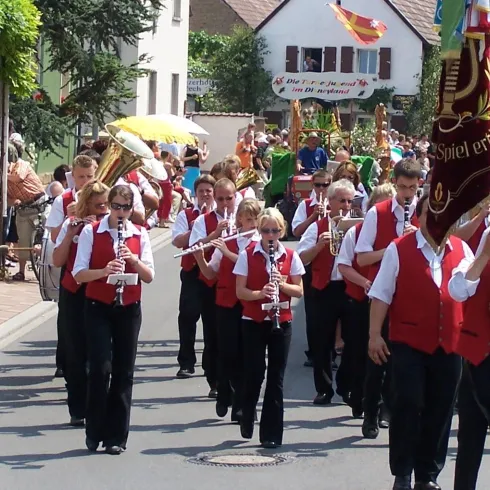 Musiker mit Blasinstrumenten laufen in einem Festumzug auf der starße 