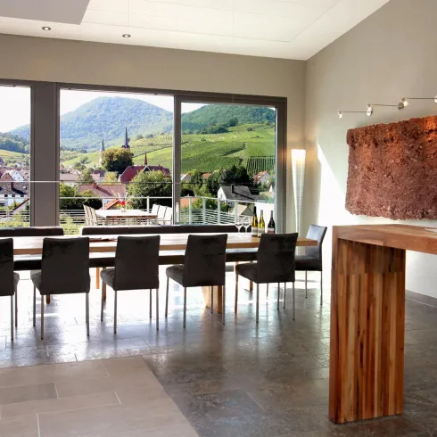 Moderne Weinbar mit Blick auf malerische Weinberge. Große Fenster bieten eine helle und einladende Atmosphäre.