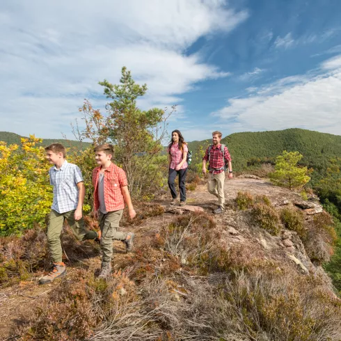 Familie auf Felskuppe auf dem Rimbach-Steig mit Pfälzerwald im Hintergrund