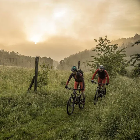 Mountainbiker*innen im Sonneraufgang