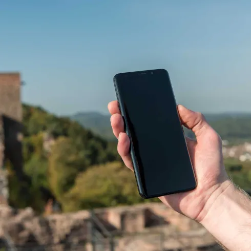 Hand mit Handy auf Burg Alt-Dahn