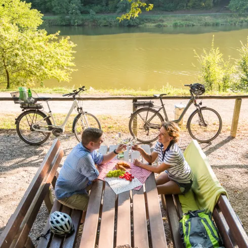 zwei Radfahrer picknicken am See