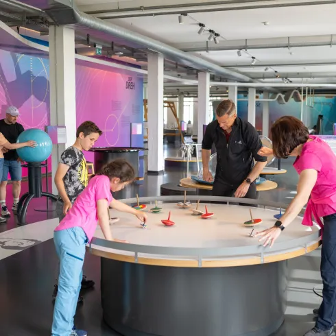 Eine Familie besucht das Dynamikum und testet eine der interaktiven Ausstellungen.