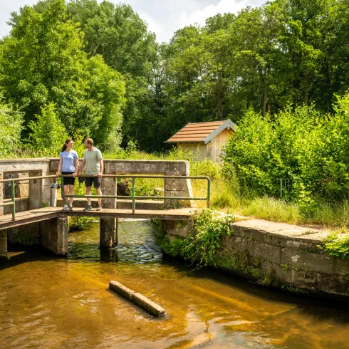 zwei Personen auf der Brücke am Bach 