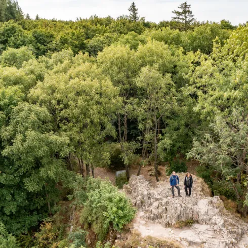 Zwei Personen wandern im Pfälzerwald beim  Donnersberggipfel.