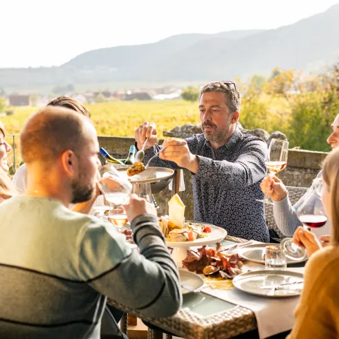 Menschen genießen ein Dinner im Außenbereich des Leinsweiler Hofs. 