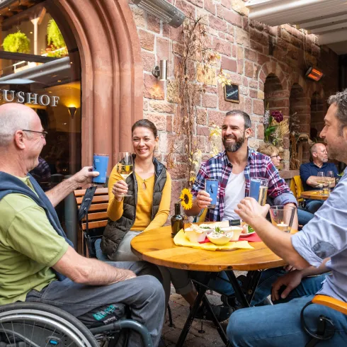 Vier Personen sitzen an einem Tisch in einem Restaurant in St. Martin. Auf dem Tisch stehen pfälzische Gerichte.