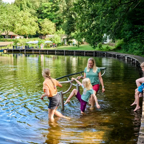 Eine Familie kneippt an einem See