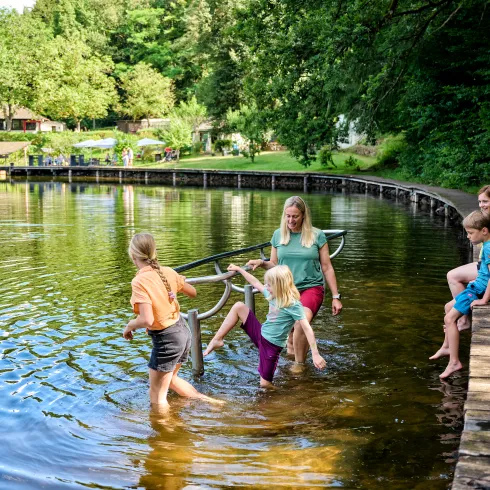 Eine Familie kneippt an einem See