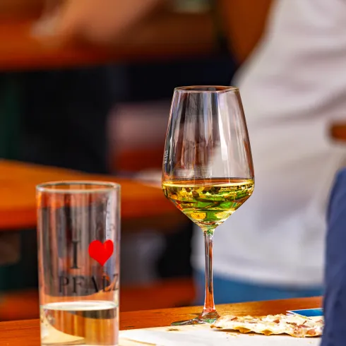 Ein Wein- und ein Schorleglas stehen auf einem Tisch. 