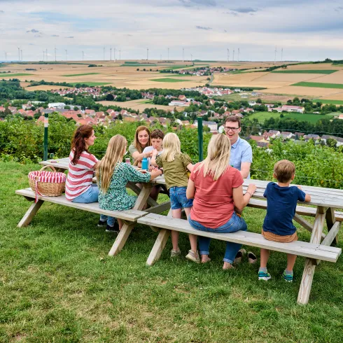Menschen sitzen an einem Picknicktisch beim Warturm