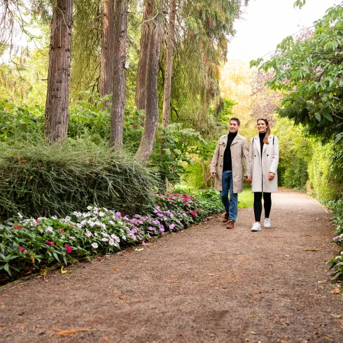 Ein Paar geht an einem Herbsttag im Schillerpark Landau spazieren.
