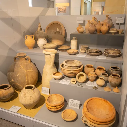 Römisches Alltagsgeschirr in einer Museumsvitrine ausgestellt.