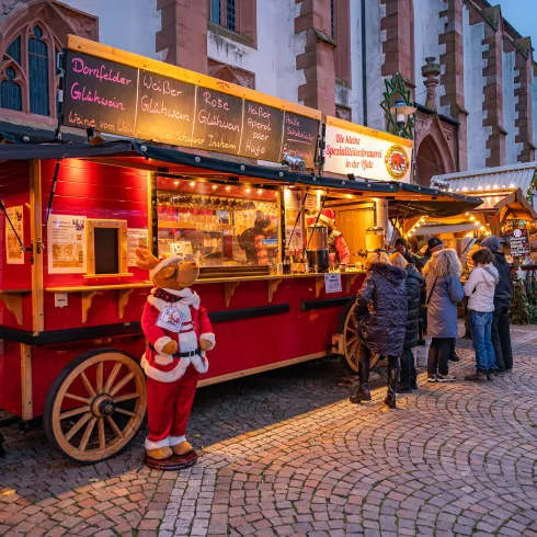 Weihnachtlich geschmückte Buden auf dem Christkindelmarkt in Kandel vor der Kirche.