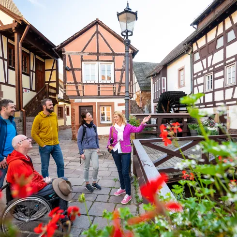 Urlauber bei einer Gästeführung durch Annweiler am Trifels mit ihrer Altstadt und den Fachwerkhäusern.