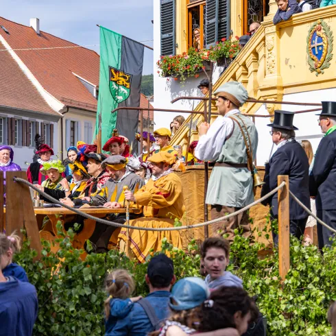 Menschen stehen in traditionellen Gewändern bei der historischen Geißbockversteigerung in Deidesheim