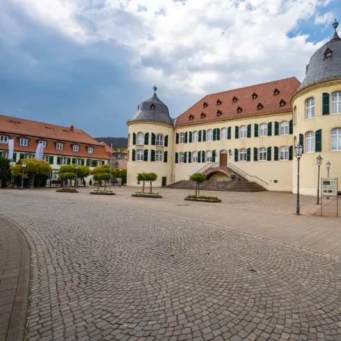 Das Schloss und Schlosshotel in Bad Bergzabern, mit gelber Fassade und grünen Fensterläden.