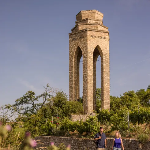 Zwei Personen spazieren vor dem Ehrenmal in Zellertal