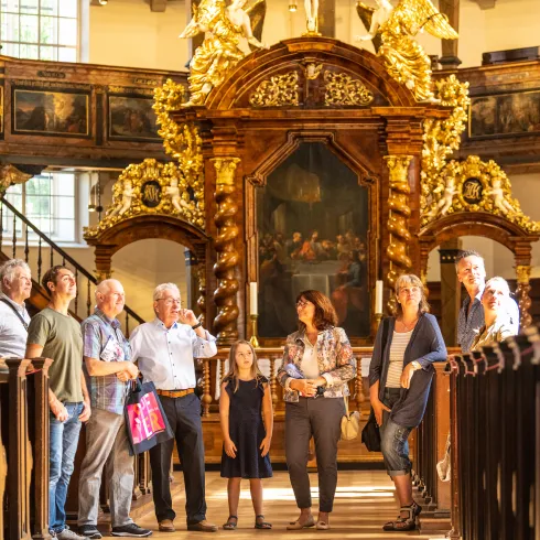 Eine Gruppe von Menschen bei einer Gästeführung in der Dreifaltigkeitskirche in Speyer