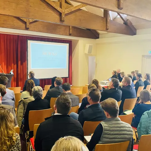 Hans-Ulrich Ihlenfeld, Vorsitzender der Pfalz Touristik und Landrat des Landkreises Bad Dürkheim, spricht vor den Teilnehmenden der Mitgliederversammlung der Pfalz Touristik. 