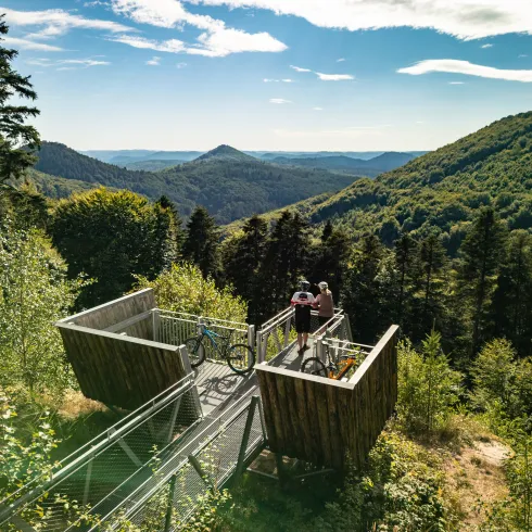 Zwei Personen stehen auf der Aussichtsplattform beim Hermersbergerhof und genießen den Ausblick auf den Pfälzerwald.